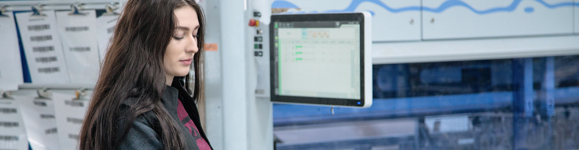 Woman checks monitor in factory environment